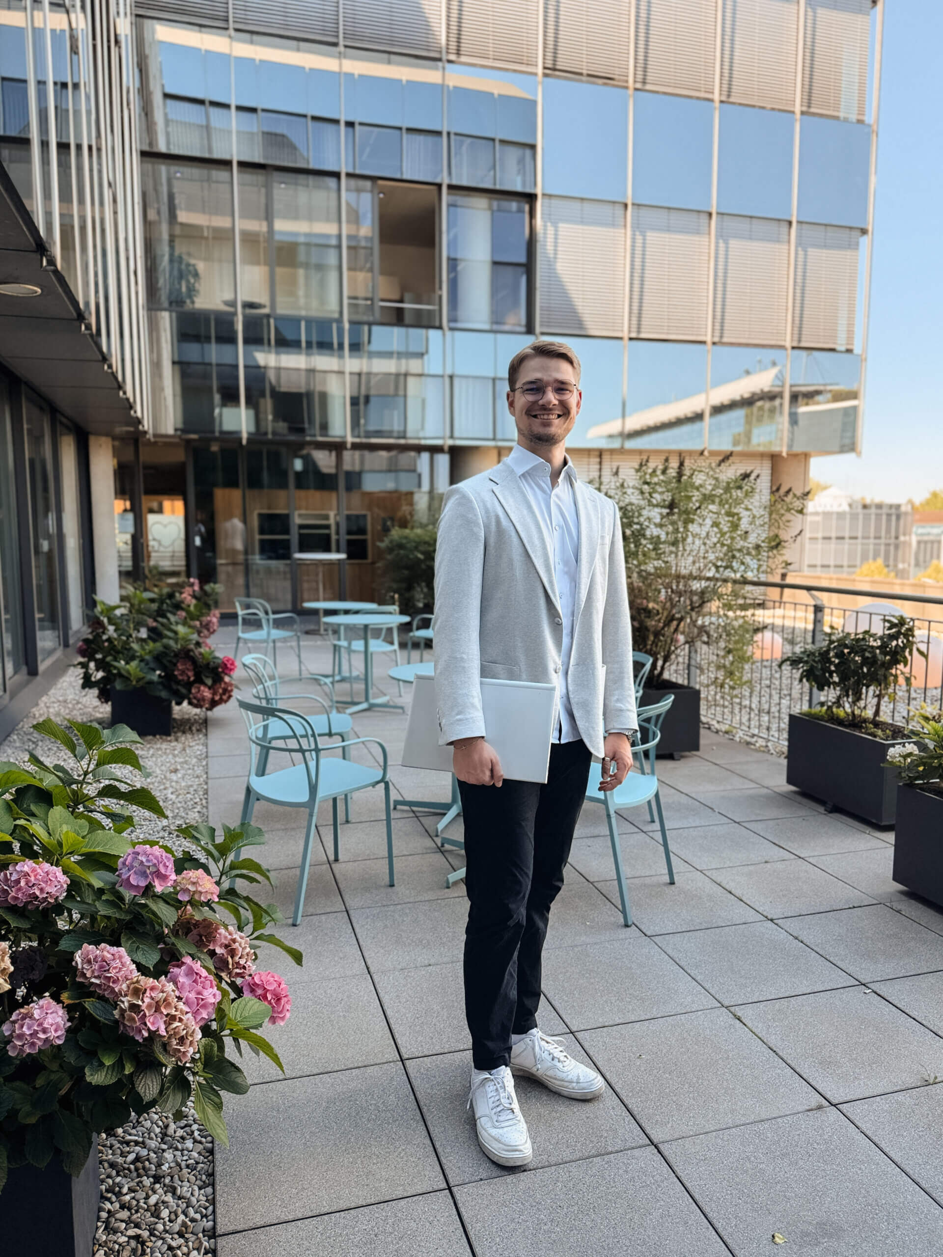 Geno-Dresscode: So kleidest du dich als Bankkaufmann, Azubi mit hellem Sakko und Hemd sowie dunkler Hose und Sneakern