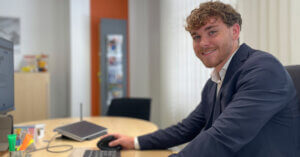 Jonas' Weg vom Studienausstieg zur Bankausbildung - Azubi sitzt am Schreibtisch