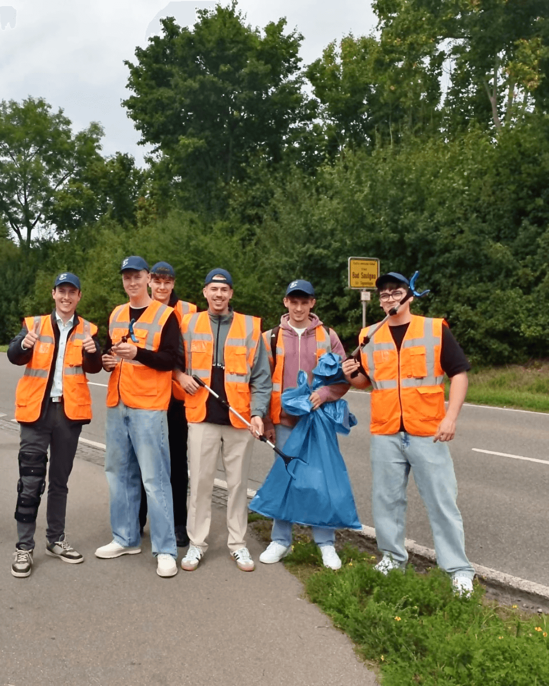 Azubi4Change-Gruppenbild: Azubis ausgerüstet mit Warnwesten, Zangen und Müllsack