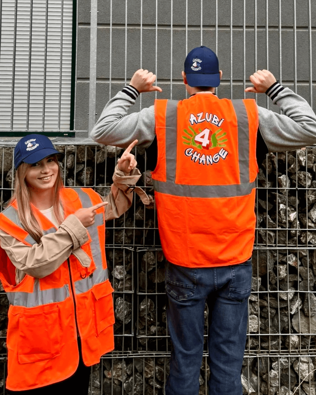 Zwei Azubis posieren in ihren Warnwesten mit dem Aufdruck Azubi4Change