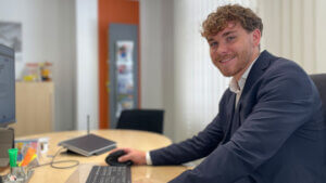 Jonas' Weg vom Studienausstieg zur Bankausbildung - Azubi sitzt am Schreibtisch