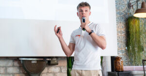 Tipps für selbstbewusstes Auftreten - Azubi hält eine Präsentation mit Mikrofon in der Hand