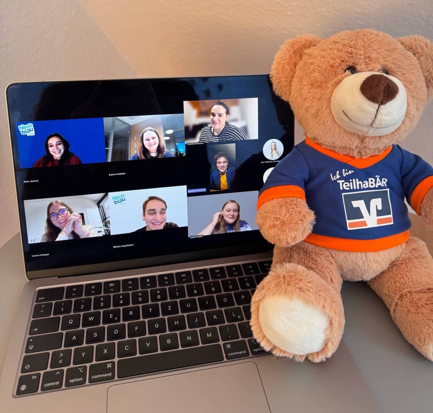 Gizem im digitalen Meeting für Neonblau - Laptop mit Volksbank-Teddy