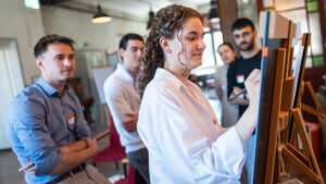 Vorbereitung zur Zwischenprüfung: Fünf Auszubildende um Plakat sammeln Notizen