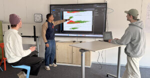 Duales Studium Data Science & KI: Drei junge Menschen analysieren Daten auf einem Bildschirm
