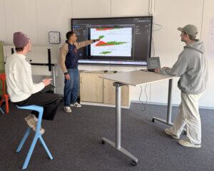 Duales Studium Data Science & KI: Drei junge Menschen analysieren Daten auf einem Bildschirm