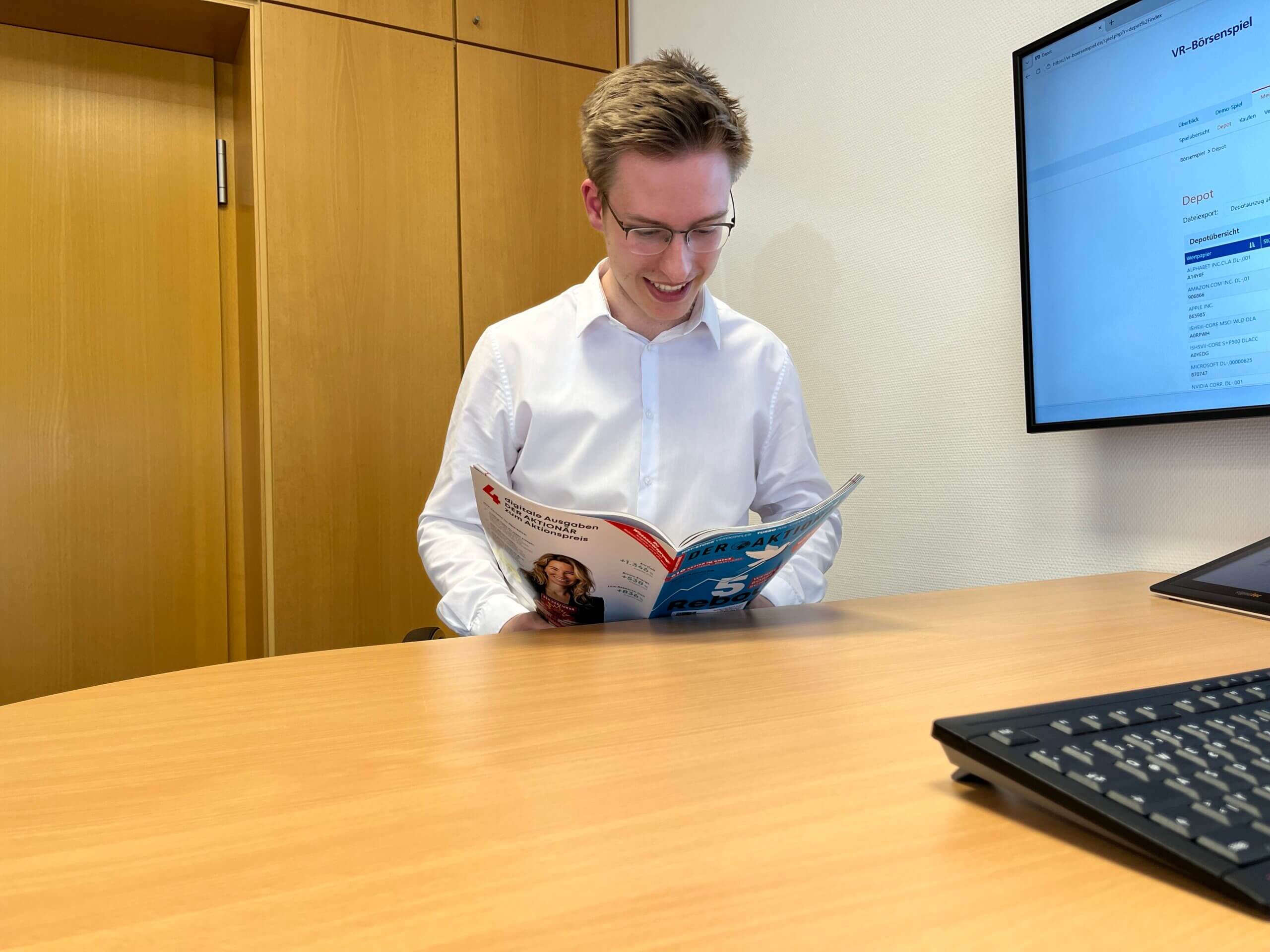Azubi liest in einem Börsenmagazin