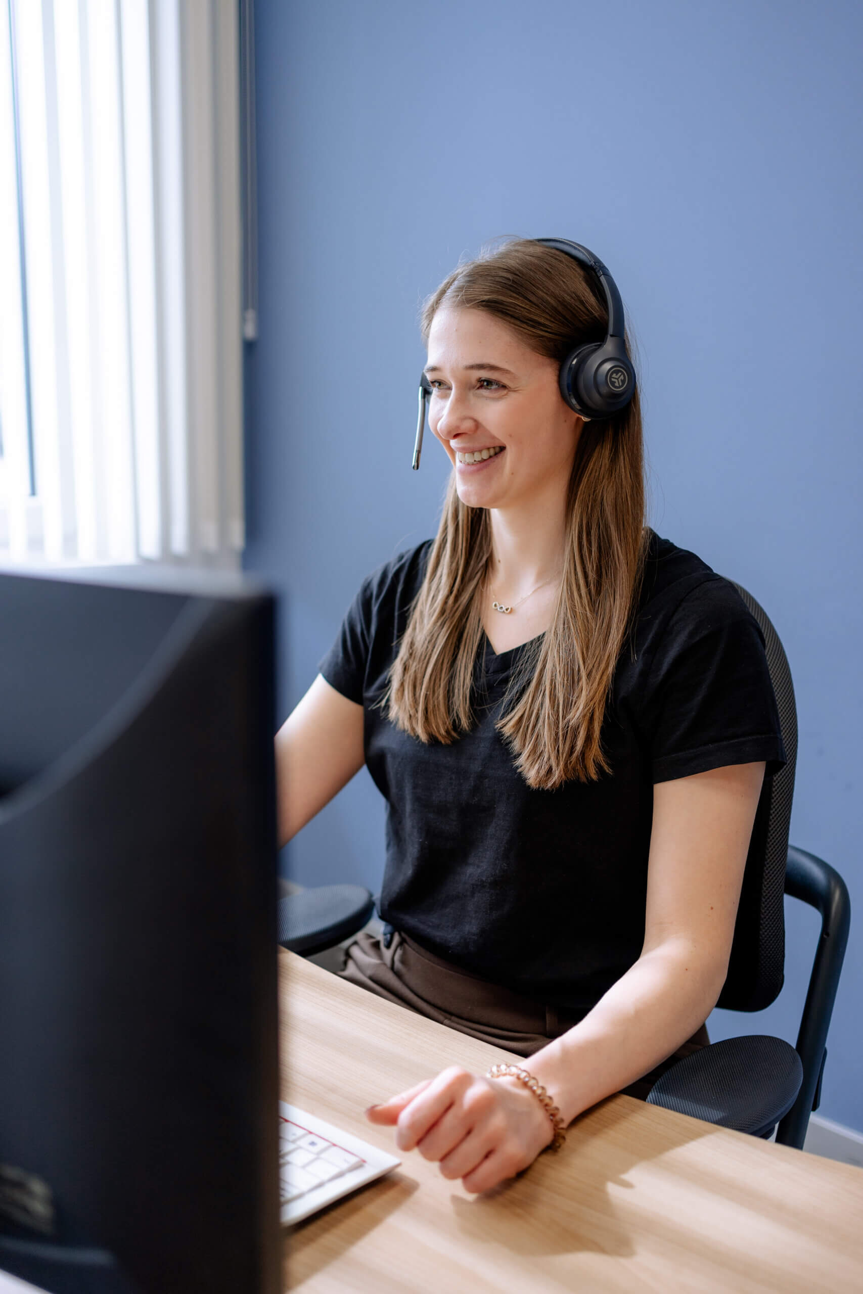 Stephanie mit Headset vor einem PC