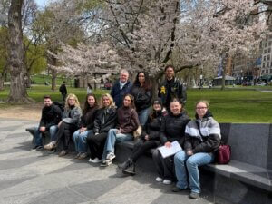 Gruppe Auszubildender sitzt auf einer Bank in einem Park