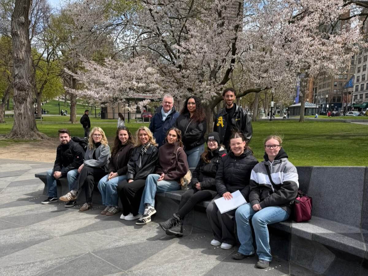 Ausflug im Rahmen des Job-Shadowing-Programms: Gruppe Auszubildender sitzt auf einer Parkbank